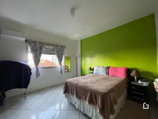 Quarto com parede verde e janela.