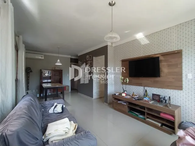 Sala de estar com parede de madeira e televisão montada.