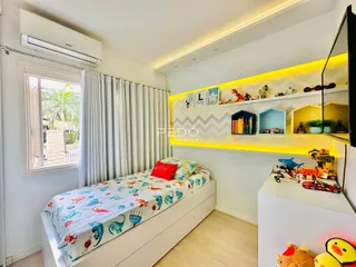 Quarto com cama e estante iluminada em um apartamento.