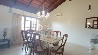Uma sala de jantar com mesa de madeira e cadeiras de madeira.