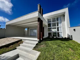 Fachada de uma residência moderna com jardim e acesso por escadaria em Lajeado, Brasil.
