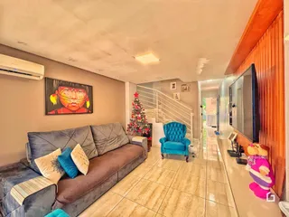 Sala de estar com sofá e escadaria em um imóvel no Brasil.