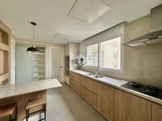 Vista da cozinha moderna com armários e bancadas claras.