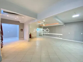 Sala ampla com piso claro e paredes brancas.