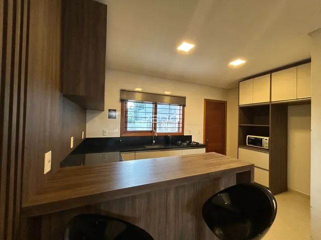 Imagem de uma cozinha com armários de madeira e ilha.