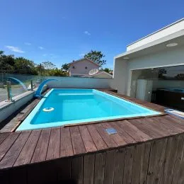 Foto de uma piscina externa com deck de madeira em uma propriedade.