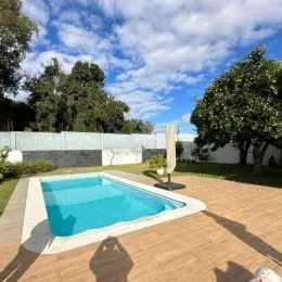 Vista externa de uma piscina com deck de madeira em uma propriedade em Lajeado.