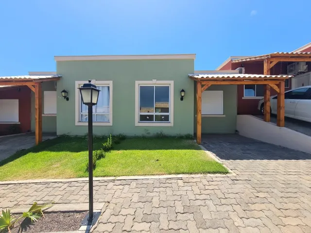 Fachada externa de uma residência em Lajeado, Brasil, com área de jardim e pergolado de madeira.