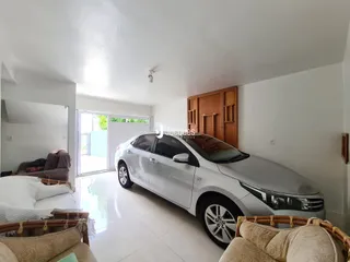 Ambiente interno claro com porta de vidro e veículo estacionado.