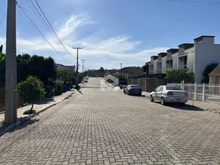 Vista da rua residencial em Lajeado, Brasil, mostrando casas e edificações.