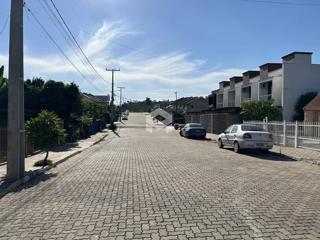 Vista da rua residencial em Lajeado, Brasil, mostrando casas e edificações.