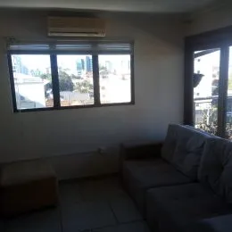 Sala de estar com sofá e janela mostrando a vista.
