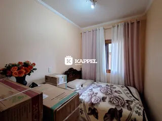 Quarto com cama e caixas de mudança em um ambiente interno.