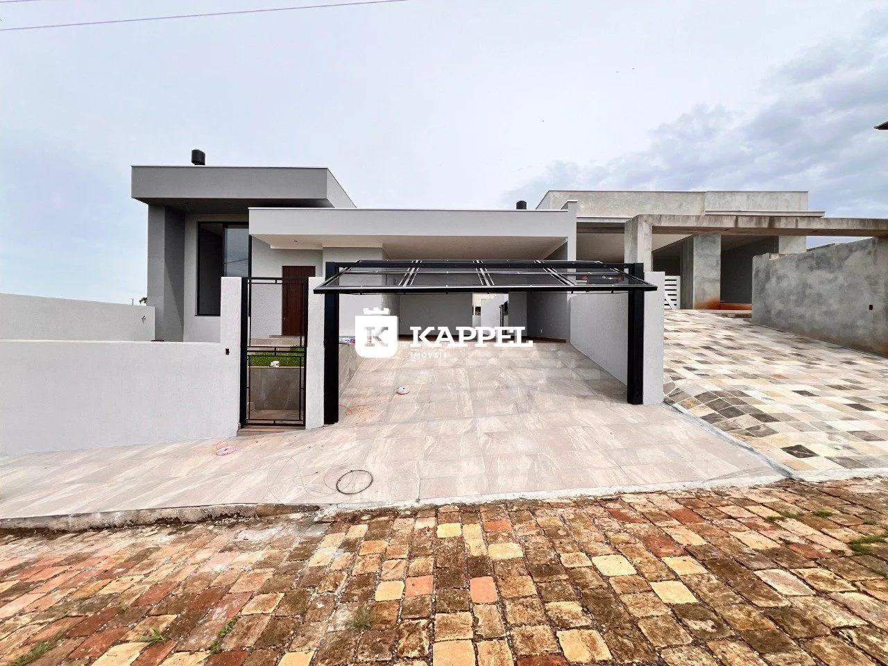 Vista externa de uma residência moderna com área coberta no jardim.