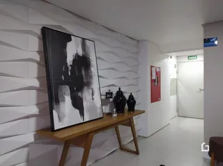 Ambiente interno com paredes brancas e uma obra de arte na parede.