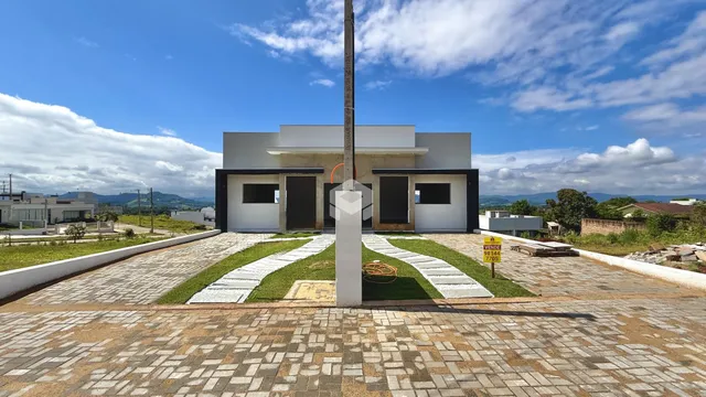 Fachada de uma casa moderna em Lajeado, Brasil com jardim frontal.