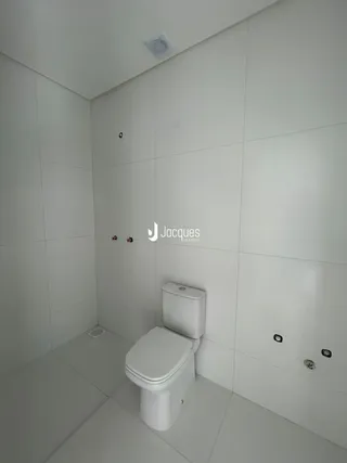 Foto de um banheiro com paredes brancas e piso claro.