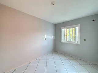 Esta é uma vista interna de um cômodo com paredes brancas e piso de cerâmica.