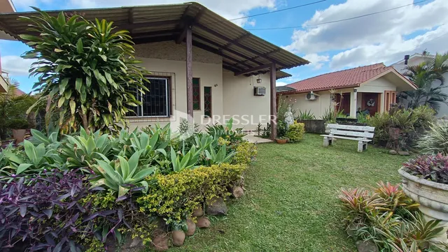 Fachada de uma casa em Lajeado, Brasil com jardim exuberante e vegetação.