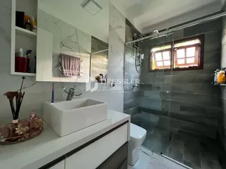 Foto de um banheiro moderno com box de vidro e bancada branca.