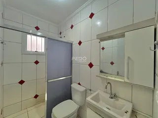 Foto do interior de um banheiro com revestimento de azulejos brancos.