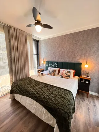 Quarto com cama grande e decoração de madeira no piso.