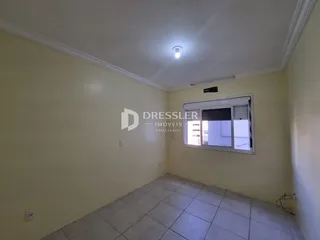 Foto de um cômodo interno com paredes amarelas e piso de cerâmica.