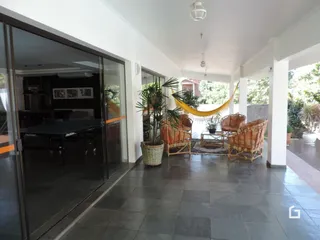 Interior de uma sala com piso de cerâmica e portas de vidro que dão acesso ao exterior.