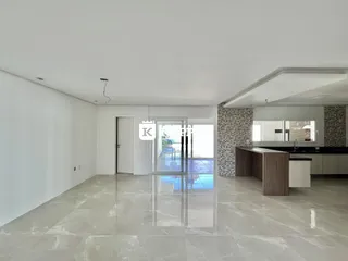 Ambiente amplo com piso claro e porta de vidro que dá acesso a uma área externa com piscina.