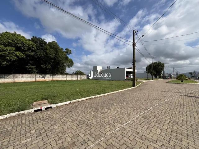 Vista externa de uma propriedade com gramado e cerca.