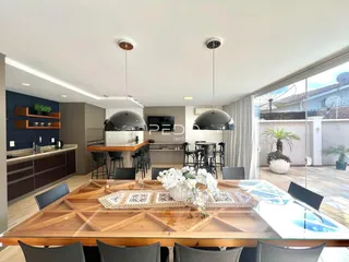 Uma sala de jantar moderna com mesa de madeira e vista para o exterior.