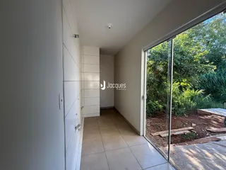 Hall de entrada com paredes brancas e piso de cerâmica.