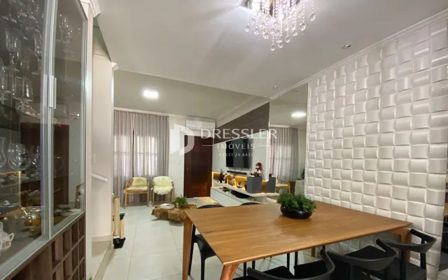 Sala de estar com decoração moderna e grandes janelas.