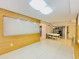 Sala de estar com piso claro e painel de madeira na residência.