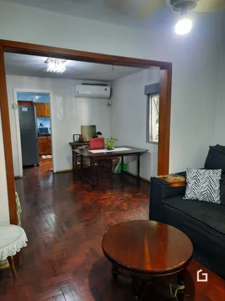 Sala de estar com piso de madeira e porta de entrada.