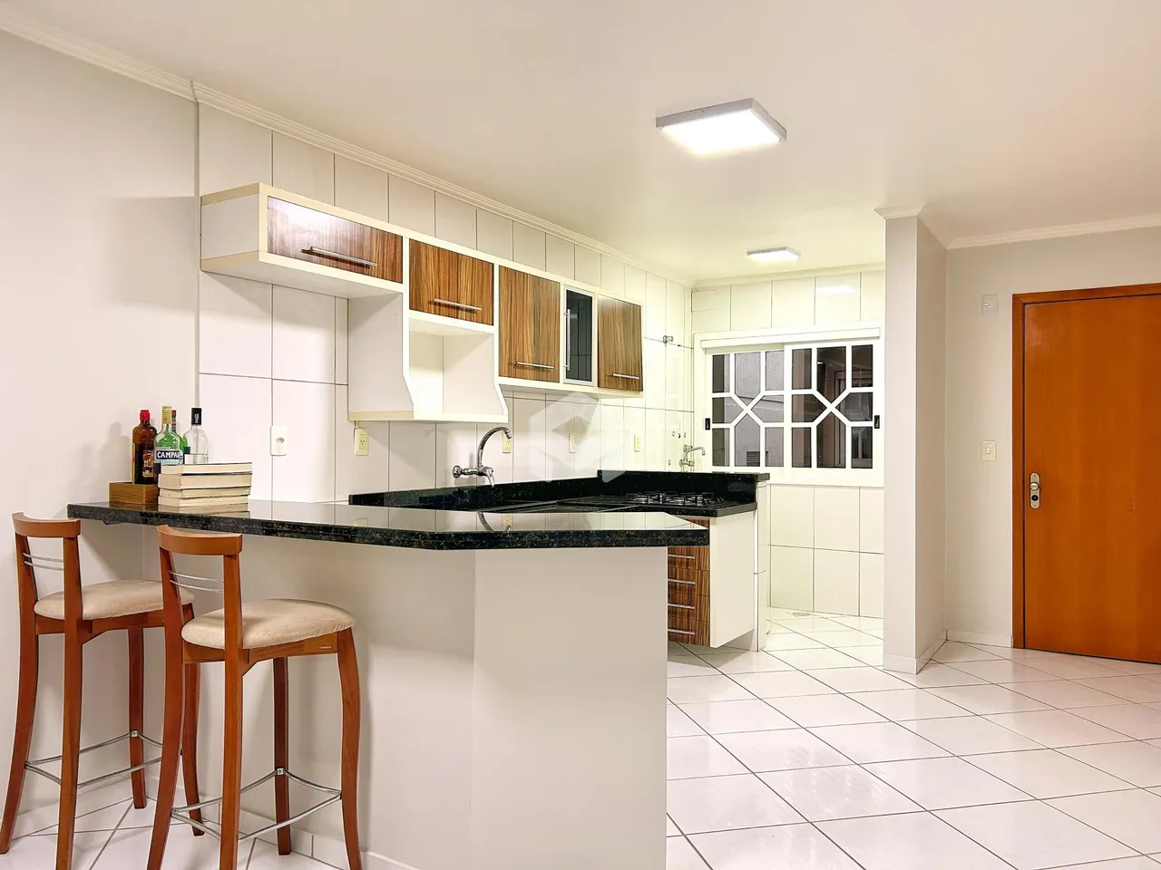 Cozinha moderna com armários de madeira e bancada escura.