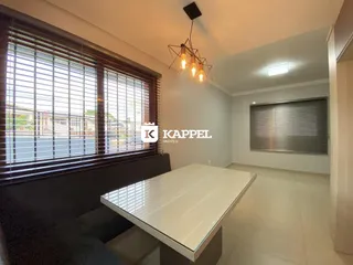 Uma sala de estar com grandes janelas e móveis modernos.