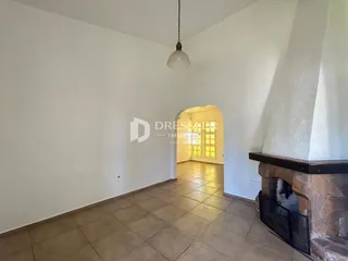 Corredor com piso de cerâmica e lareira de pedra.