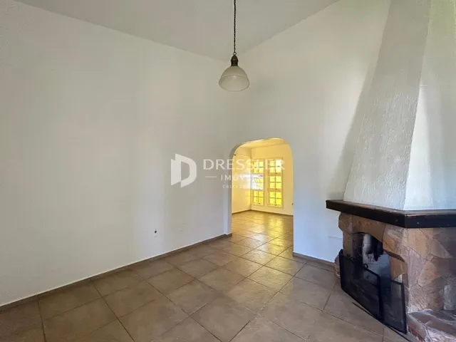 Corredor com piso de cerâmica e lareira de pedra.