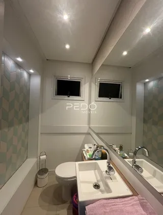 Foto de um banheiro interno com pia e vaso sanitário.