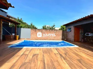 Foto de uma área externa com piscina e deck de madeira em uma propriedade.