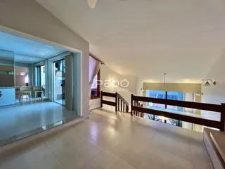 Vista interna de uma área comum com piso de cerâmica clara em um imóvel no Brasil.