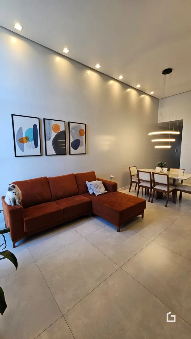 Sala de estar moderna com um sofá grande e piso claro.