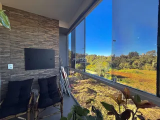 Vista da varanda com paisagem verde e céu azul.