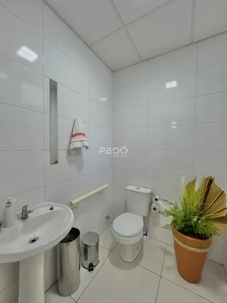 Foto de um banheiro com revestimento cerâmico branco.