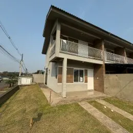 Fachada de uma casa de dois andares em Lajeado, Brasil, com varanda no andar superior.
