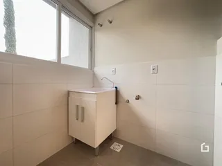 Foto de um banheiro com janela e revestimento claro.