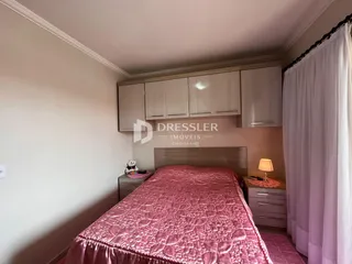 Quarto com cabeceira e armários em madeira.