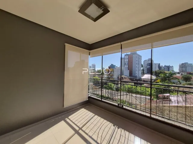 Vista interna de um ambiente com grande janela de vista para a paisagem urbana.