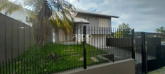 Vista da fachada de uma residência com cerca e jardim em Lajeado.